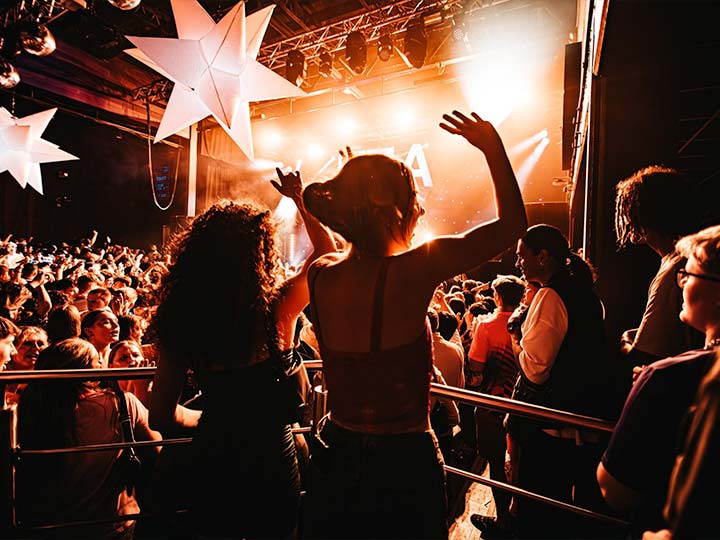 A photograph of people dancing at a club event at LCR