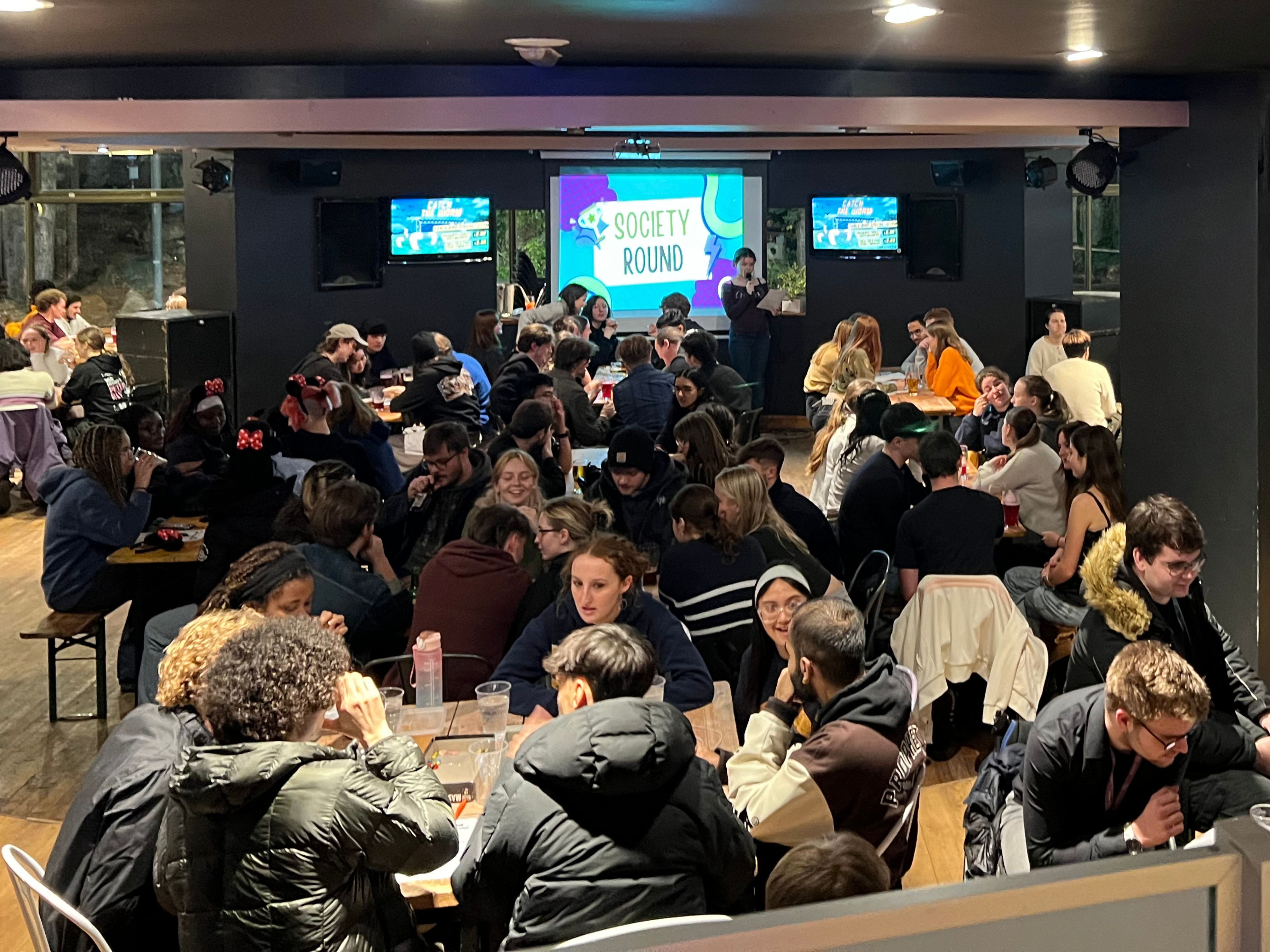 A photograph of a large group of students playing a quiz