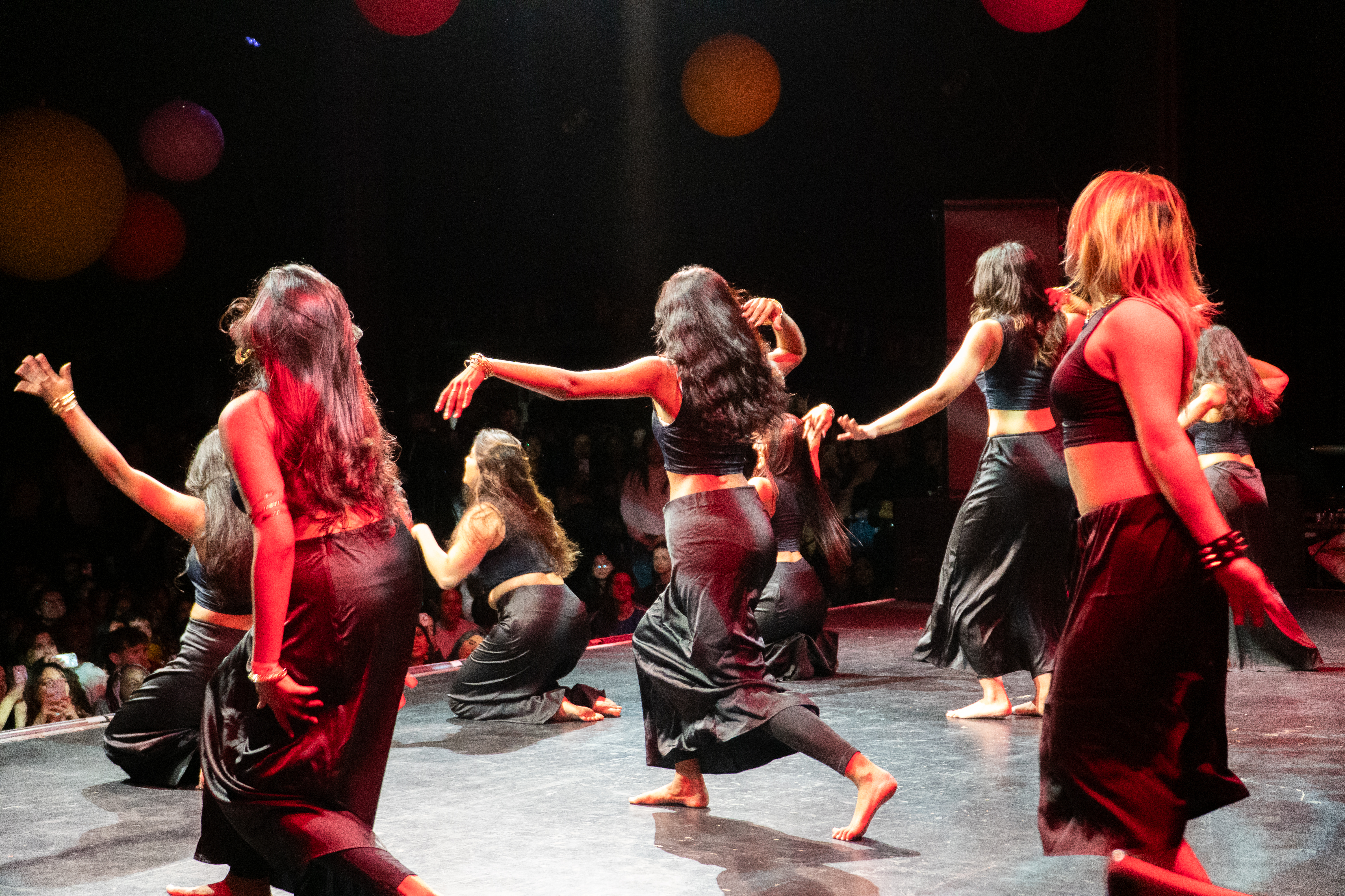 A photograph of students dancing on stage