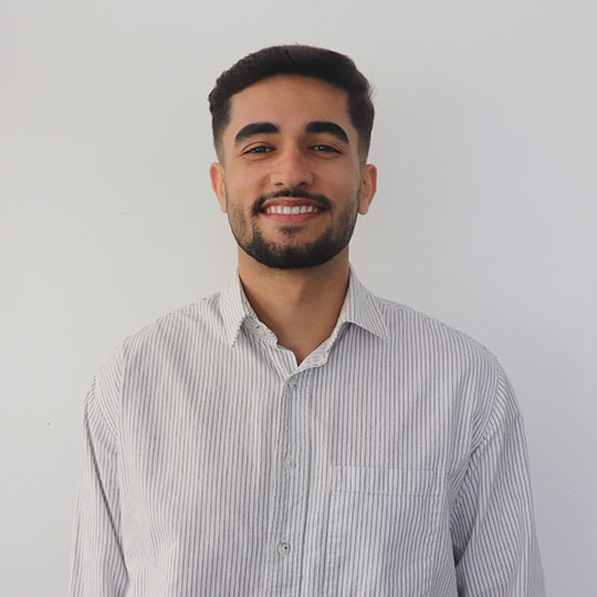 Amjad smiling against a white background  