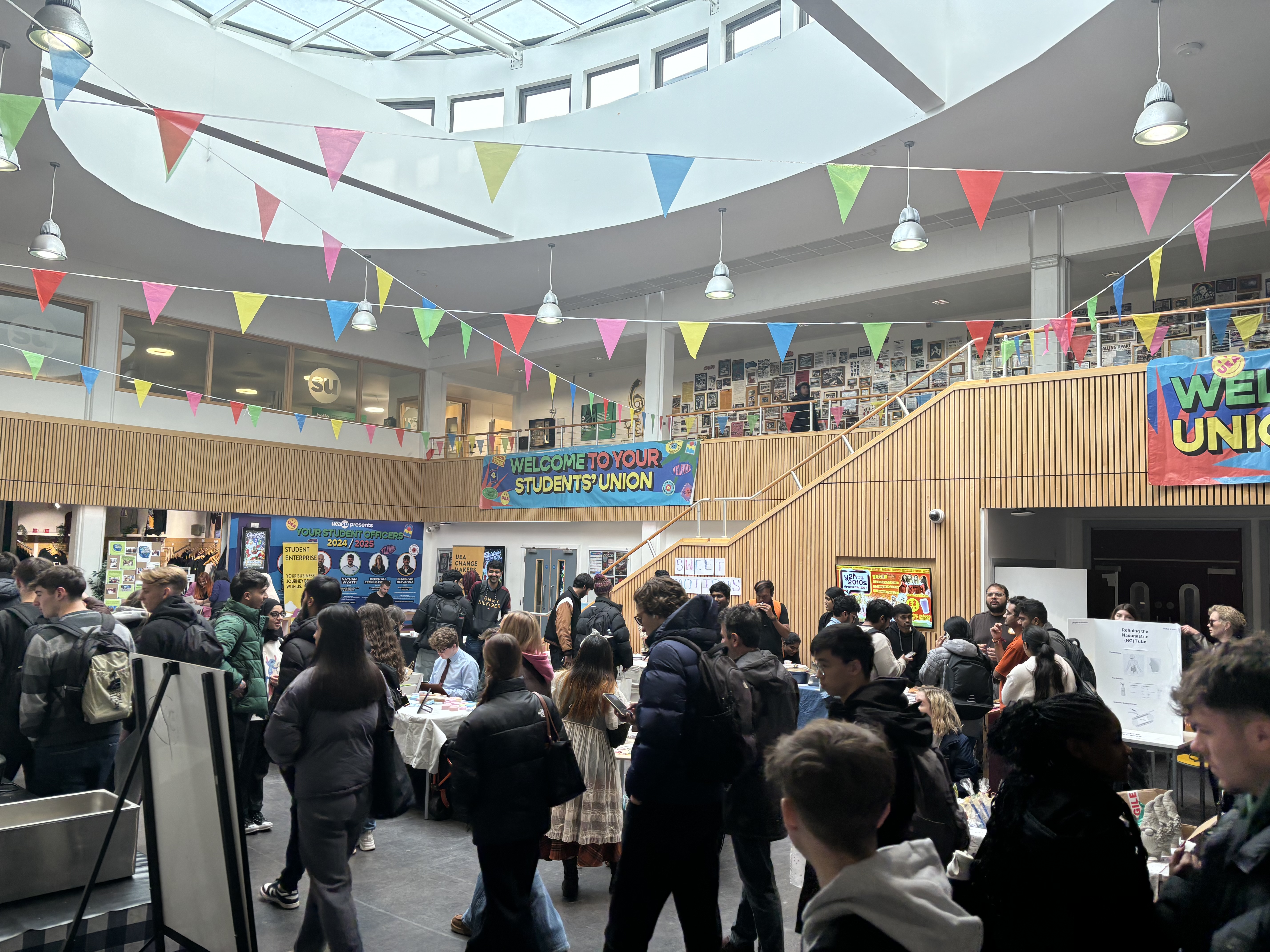 A photograph of an event at the students' union with multi-coloured flags across the ceiling.