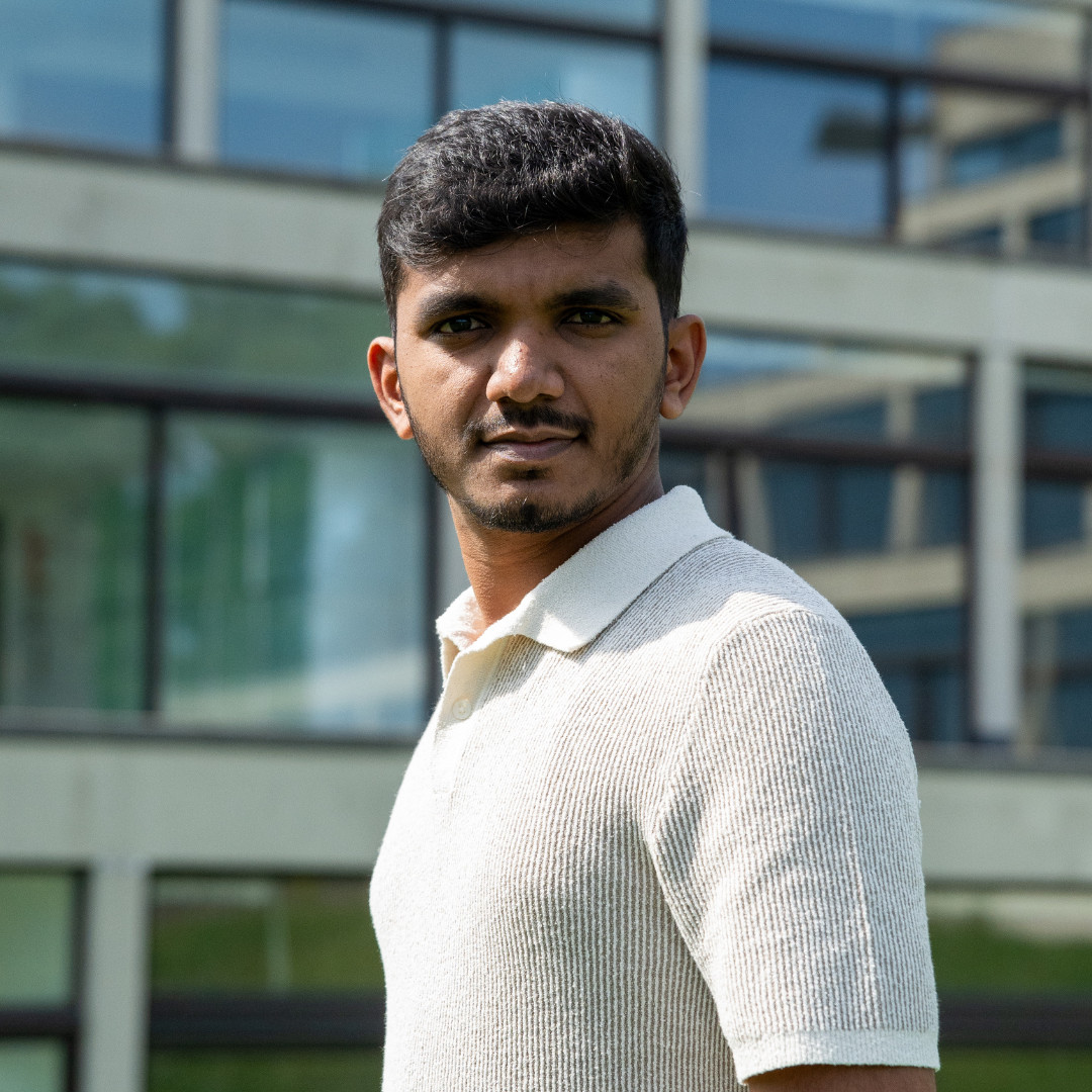 Bhaskar smiling against a backdrop of trees