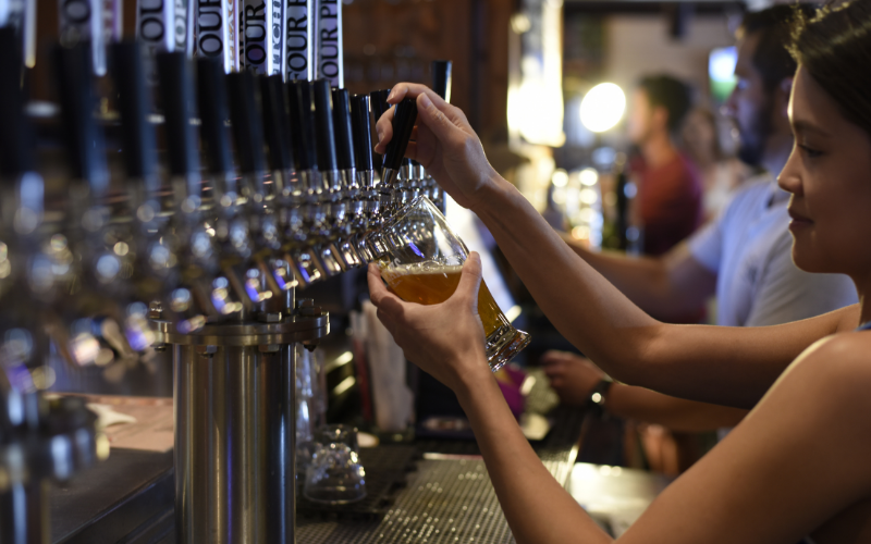 student working behind a bar